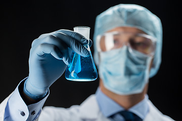 Image showing close up of scientist holding flask with chemical