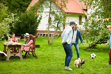 Image showing friends playing football with dog at summer garden