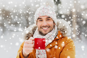 Image showing happy man with tea cup outdoors in winter