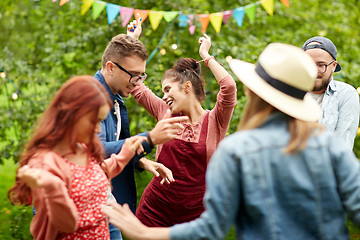 Image showing happy friends dancing at summer party in garden