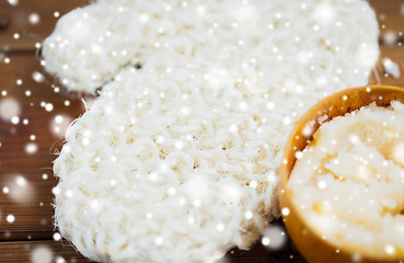 Image showing close up of wisp and body scrub in cup on wood