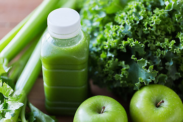 Image showing close up of bottle with green juice and vegetables