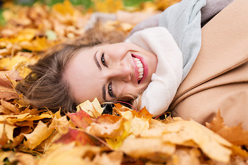 Image showing beautiful happy woman lying on autumn leaves