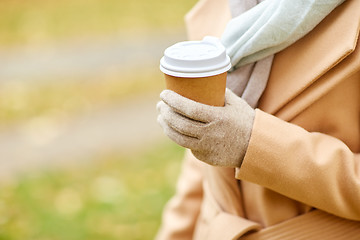 Image showing close up of woman with coffee in autumn park