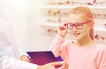 Image showing optician and girl choosing glasses at optics store