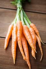 Image showing close up of carrot bunch on wooden table