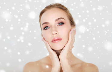 Image showing beautiful young woman face and hands over snow