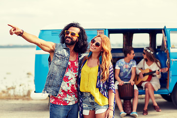 Image showing smiling young hippie couple over minivan car