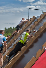 Image showing Athlete gets on inclined wall by means of bar