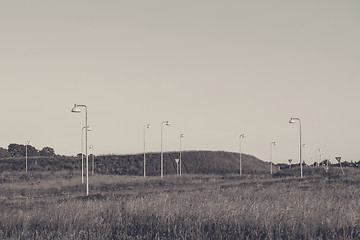 Image showing Many streetlamps on a meadow
