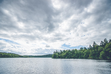 Image showing Dark clouds over a forest lake