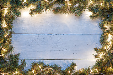 Image showing New year light blue wooden background with lightbulb and branches