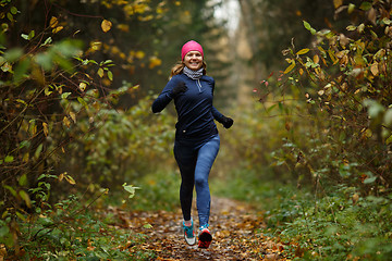 Image showing Portrait in full growth of sporty woman jogging in park