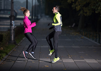 Image showing a young couple warming up before jogging