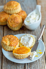 Image showing Scones with orange jam and whipped cream for breakfast.