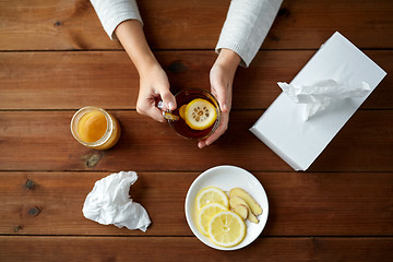 Image showing ill woman drinking tea with lemon and ginger