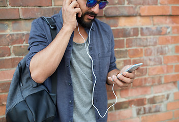 Image showing man with earphones, smartphone and bag on street