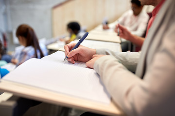 Image showing student writing to notebook at exam or lecture