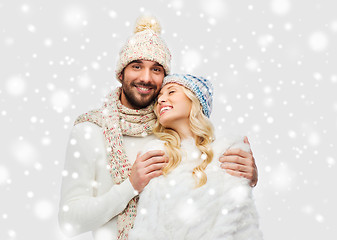 Image showing smiling couple in winter clothes hugging over snow