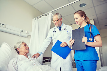 Image showing doctor and nurse visiting senior woman at hospital