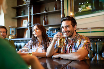 Image showing happy friends drinking beer at bar or pub