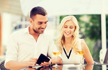 Image showing happy couple with wallet and bill at restaurant