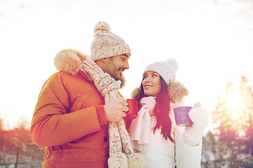 Image showing happy couple with tea cups over winter landscape