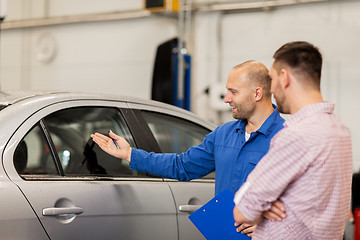 Image showing auto mechanic with clipboard and man at car shop