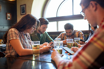 Image showing friends with smartphones and beer at bar or pub