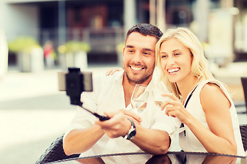 Image showing happy couple taking selfie with smartphone at cafe