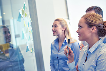 Image showing smiling business people with marker and stickers