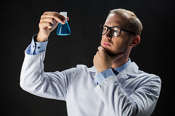 Image showing young scientist holding test flask with chemical