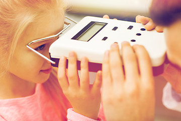 Image showing optician with pupillometer and girl at eye clinic