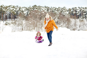 Image showing happy father pulling sled with child in winter