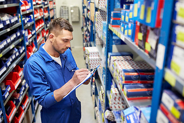 Image showing auto mechanic with clipboard at car workshop