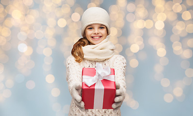 Image showing smiling girl in winter clothes with christmas gift