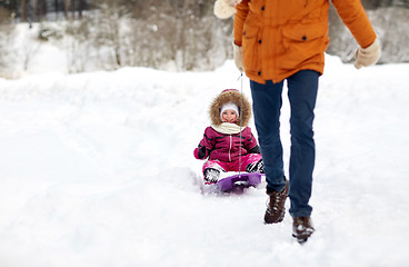 Image showing father pulling sled with happy child in winter