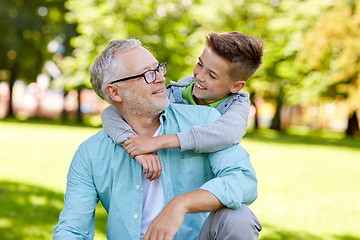 Image showing grandfather and grandson hugging at summer park