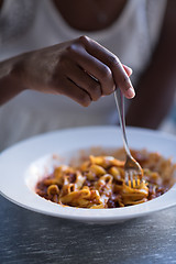 Image showing a young African American woman eating pasta