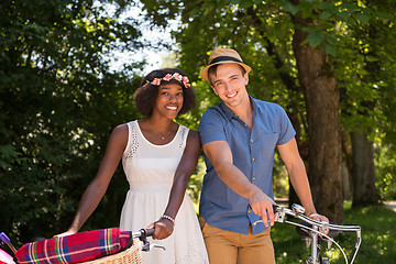 Image showing Young multiethnic couple having a bike ride in nature