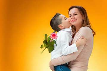 Image showing Young kid giving red rose to his mom