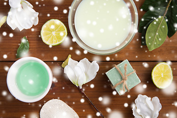 Image showing body lotion, cream and handmade soap on wood