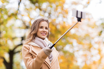 Image showing woman taking selfie by smartphone in autumn park