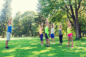 Image showing group of friends or sportsmen exercising outdoors