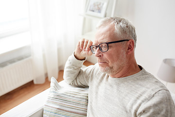 Image showing  senior man sitting on sofa at home and thinking