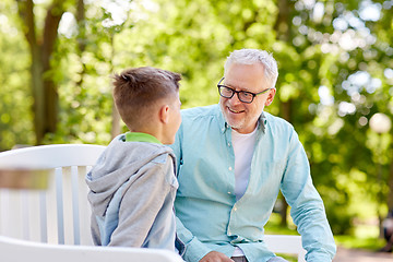 Image showing grandfather and grandson talking at summer park