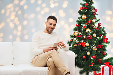 Image showing smiling man with smartphone for christmas
