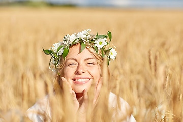 Image showing happy woman in wreath of flowers on cereal field