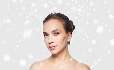 Image showing beautiful young woman face over snow