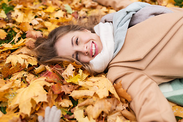 Image showing beautiful happy woman lying on autumn leaves